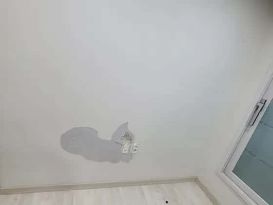 벽지 한 조각이 벗겨진 흰 벽